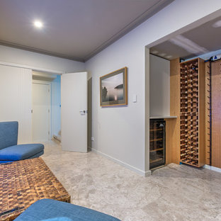 This is an example of a contemporary fully buried basement in Perth with white walls and grey floor.
