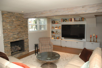 Photo of a classic walk-out basement in DC Metro with a standard fireplace and a stone fireplace surround.