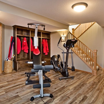 Basement - mid-sized traditional look-out medium tone wood floor basement idea in Minneapolis with beige walls, no fireplace and a stone fireplace