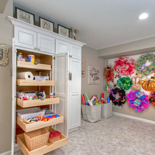 Réalisation d'un très grand sous-sol design donnant sur l'extérieur avec un mur beige, un sol en vinyl et une cheminée standard.