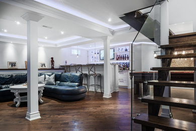 Mid-sized trendy underground dark wood floor and brown floor basement photo in Toronto with white walls, a standard fireplace and a tile fireplace