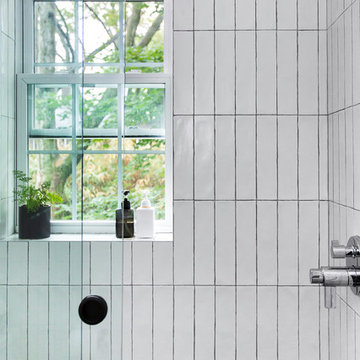 Glass-enclosed shower with vertically-stacked subway tile