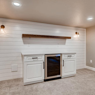 Inspiration pour un sous-sol rustique semi-enterré et de taille moyenne avec un bar de salon, un mur blanc, moquette, un sol beige et du lambris de bois.