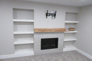 Basement - modern carpeted basement idea in Edmonton with no fireplace and a tile fireplace