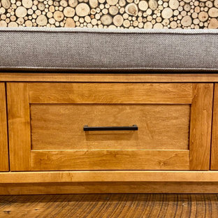 Exemple d'un sous-sol craftsman donnant sur l'extérieur et de taille moyenne avec salle de jeu, un mur blanc, un sol en bois brun, une cheminée standard, un manteau de cheminée en pierre, un sol marron, un plafond en lambris de bois et du lambris de bois.