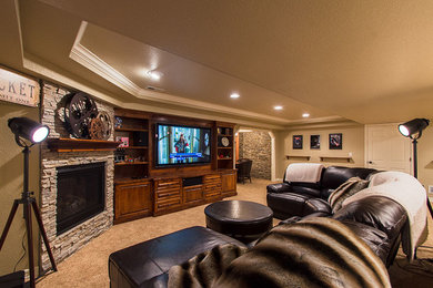 Basement - large traditional underground carpeted and beige floor basement idea in Denver with beige walls, a stone fireplace and a standard fireplace
