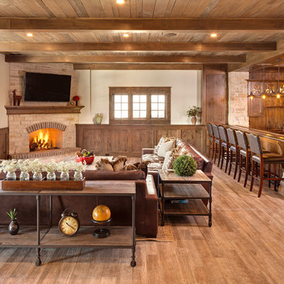 Basement - large rustic walk-out light wood floor and beige floor basement idea in Chicago with beige walls, a corner fireplace and a stone fireplace
