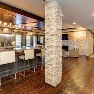 Inspiration pour un grand sous-sol traditionnel donnant sur l'extérieur avec un mur gris, un sol en ardoise, une cheminée standard, un manteau de cheminée en pierre et un sol multicolore.