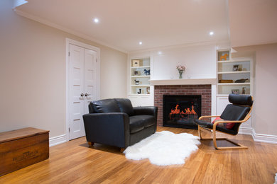 Example of an eclectic underground bamboo floor basement design in Toronto with a standard fireplace and a brick fireplace