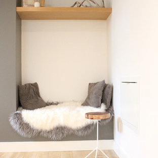 Aménagement d'un sous-sol scandinave semi-enterré et de taille moyenne avec un mur blanc et un sol en bois clair.