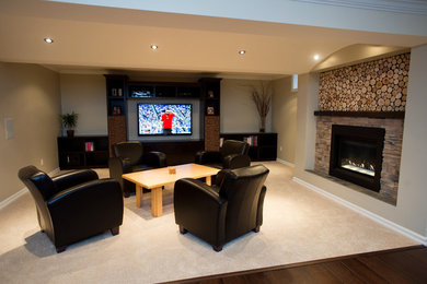 Large contemporary fully buried basement in Toronto with beige walls, medium hardwood flooring and a standard fireplace.