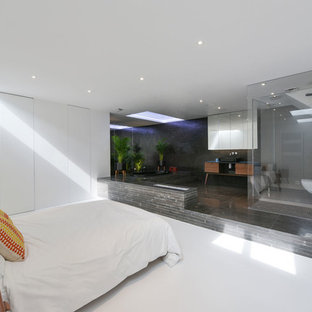 Idée de décoration pour un grand sous-sol design enterré avec un mur blanc et un sol blanc.