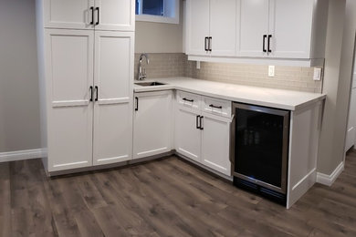 Example of a mid-sized transitional look-out laminate floor and gray floor basement design in Other with gray walls