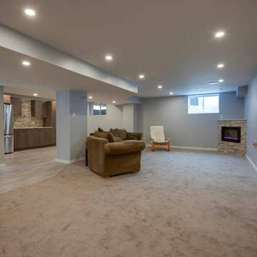 Modern finished basement with built-in bar and fireplace