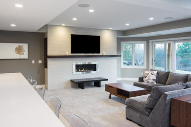 Large trendy walk-out carpeted and gray floor basement photo in Detroit with gray walls, a ribbon fireplace and a tile fireplace