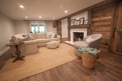 Inspiration for a large rustic look-out medium tone wood floor and brown floor basement remodel in Richmond with a standard fireplace, a brick fireplace and white walls