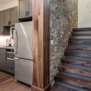 Idée de décoration pour un sous-sol chalet enterré et de taille moyenne avec un mur blanc, un sol en bois brun et un sol marron.