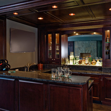 Pub Style Basement Wet Bar featuring Dark Stained Raised Panel Cabinetry