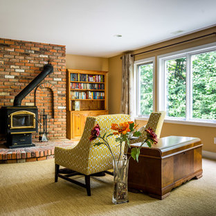 Cette photo montre un très grand sous-sol tendance donnant sur l'extérieur avec un mur beige, moquette, un poêle à bois et un manteau de cheminée en brique.