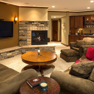 Elegant underground carpeted and beige floor basement photo in Minneapolis with beige walls, a corner fireplace and a stone fireplace