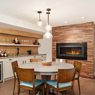 Inspiration pour un grand sous-sol traditionnel enterré avec un mur gris, une cheminée ribbon, un sol en liège, un manteau de cheminée en métal et un sol marron.