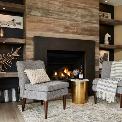 Inspiration for a mid-sized transitional walk-out light wood floor and gray floor basement remodel in Minneapolis with gray walls, a standard fireplace and a metal fireplace