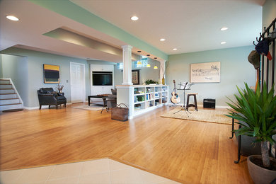 Großes Modernes Untergeschoss ohne Kamin mit grüner Wandfarbe und braunem Holzboden in Cleveland