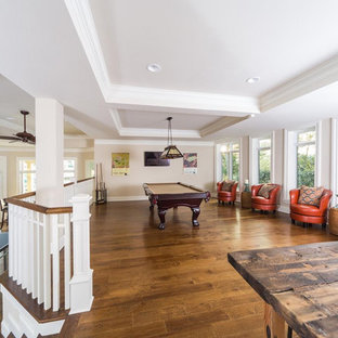 Idée de décoration pour un grand sous-sol tradition donnant sur l'extérieur avec salle de jeu, un mur beige, un sol en bois brun, aucune cheminée, un sol marron et un plafond décaissé.