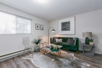 トロントにあるお手頃価格の中くらいなコンテンポラリースタイルのおしゃれな地下室 (白い壁、暖炉なし、半地下 (窓あり) 、ラミネートの床、茶色い床) の写真
