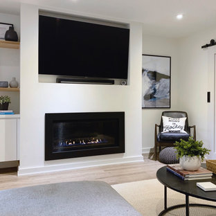 Idées déco pour un sous-sol contemporain enterré avec un mur blanc, un sol en vinyl, une cheminée standard et un manteau de cheminée en plâtre.