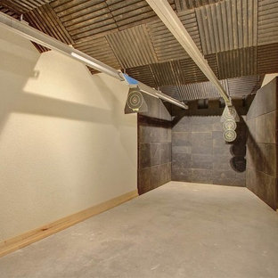 Inspiration pour un grand sous-sol chalet donnant sur l'extérieur avec un mur marron, une cheminée standard et un manteau de cheminée en pierre.