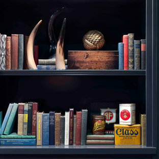 Idée de décoration pour un grand sous-sol tradition enterré avec un mur gris, un sol en bois foncé, aucune cheminée et un sol marron.