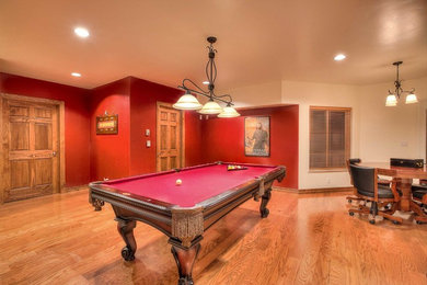 Example of a walk-out medium tone wood floor basement design in Albuquerque with red walls and no fireplace