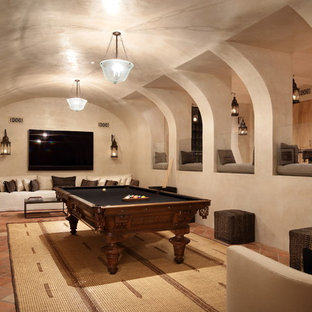 Foto di una taverna mediterranea con pareti beige, pavimento in terracotta, pavimento arancione e sala giochi