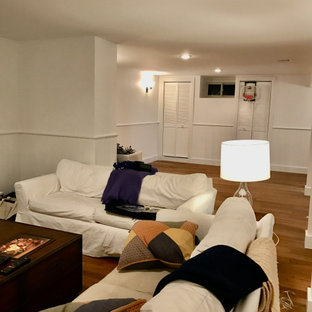 Idée de décoration pour un sous-sol design enterré et de taille moyenne avec un bar de salon, un sol en bambou, un manteau de cheminée en plâtre et boiseries.