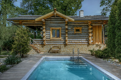 Exemple d'une piscine rectangle avec une terrasse en bois.