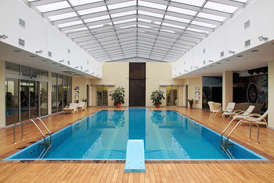 На фото: огромный спортивный, прямоугольный бассейн в доме в современном стиле с настилом и джакузи с