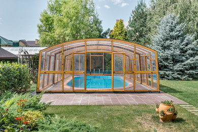 Large contemporary custom shaped above ground swimming pool in Other with brick paving.