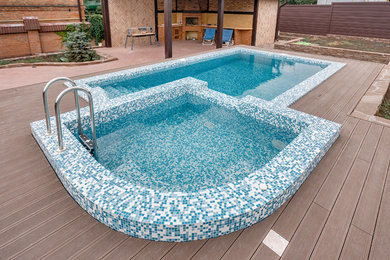 Design ideas for a medium sized classic side custom shaped infinity swimming pool in Other with a pool house and decking.