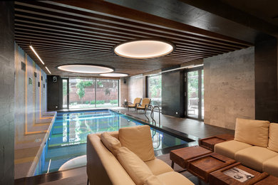 На фото: спортивный, прямоугольный бассейн среднего размера в доме в стиле модернизм с