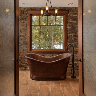 Foto di una stanza da bagno rustica con vasca freestanding e pavimento marrone