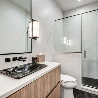 Alcove shower - mid-sized contemporary 3/4 white tile and porcelain tile black floor, single-sink and ceramic tile alcove shower idea in Dallas with flat-panel cabinets, medium tone wood cabinets, a two-piece toilet, a vessel sink, a hinged shower door, white countertops, a floating vanity and white walls