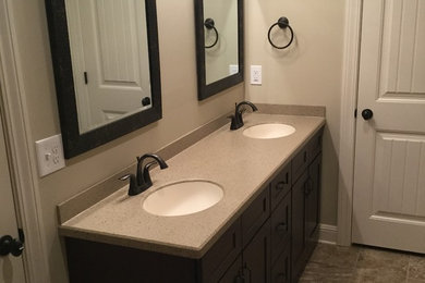Example of a small transitional master ceramic tile bathroom design in Other with shaker cabinets, dark wood cabinets, beige walls, an undermount sink and granite countertops