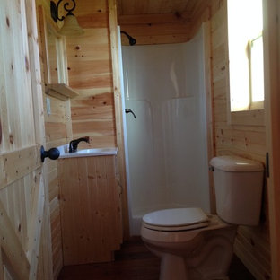 Idee per una piccola stanza da bagno con doccia american style con lavabo integrato, ante con bugna sagomata, ante in legno chiaro, top in superficie solida, doccia ad angolo, WC monopezzo, pareti beige e pavimento in legno massello medio