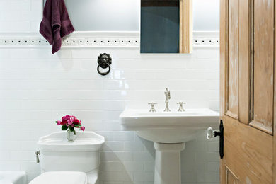 This is an example of a small victorian bathroom in New York with an alcove bath, a shower/bath combination, a one-piece toilet, white tiles, metro tiles, grey walls, marble flooring, a pedestal sink and a shower curtain.