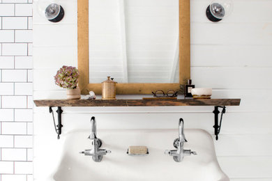 This is an example of a farmhouse ensuite bathroom in San Luis Obispo with a trough sink, a walk-in shower, white tiles, metro tiles, white walls and ceramic flooring.