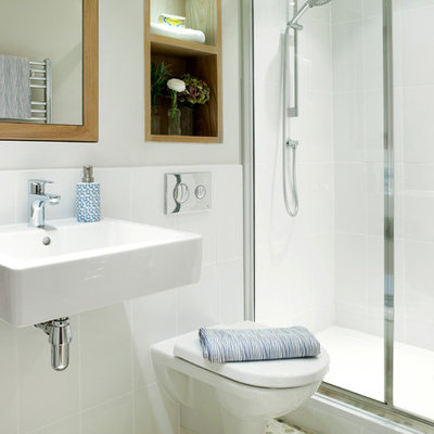Small transitional white tile and ceramic tile pebble tile floor alcove shower photo in London with a wall-mount sink, a wall-mount toilet and white walls