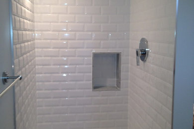 Alcove shower - modern white tile and ceramic tile laminate floor alcove shower idea in Ottawa with raised-panel cabinets, white cabinets, wood countertops and a two-piece toilet