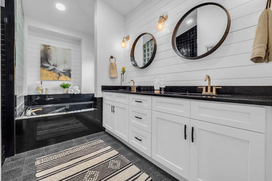 Large transitional master gray floor, double-sink and shiplap wall bathroom photo in Orlando with shaker cabinets, white cabinets, an undermount tub, white walls, an undermount sink, black countertops and a built-in vanity