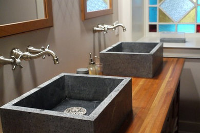 Imagen de cuarto de baño campestre con lavabo sobreencimera y encimera de madera
